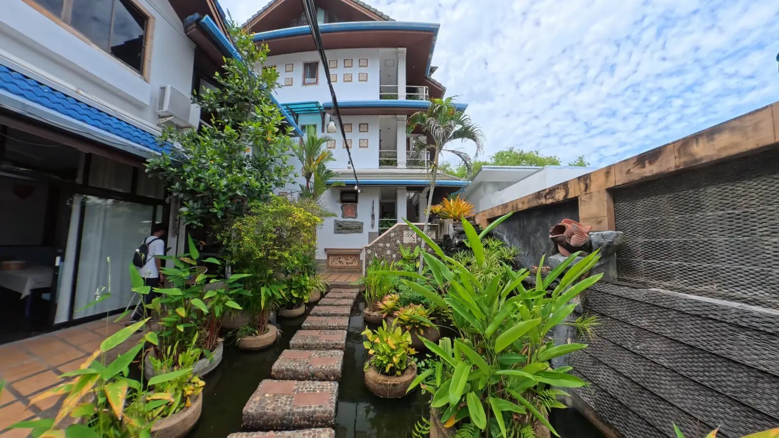 Lush gardens and pool area at The Nai Harn Collective